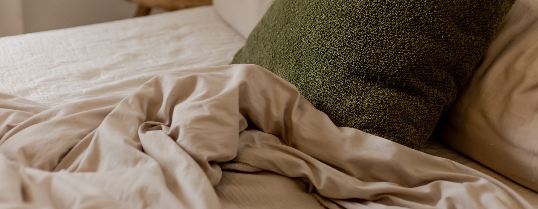 a bed with a green pillow