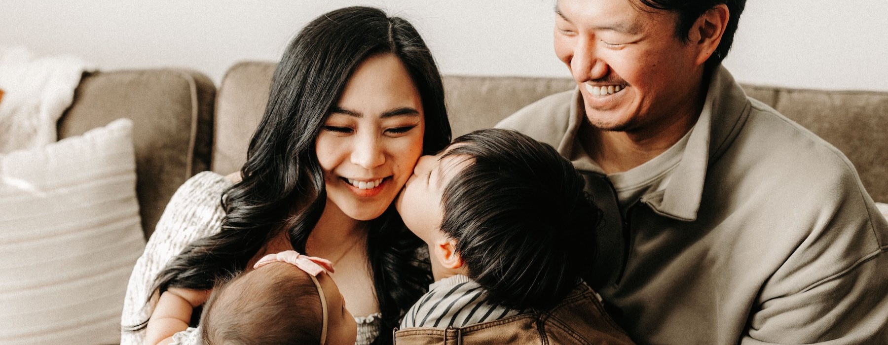 a family smiling on a couch