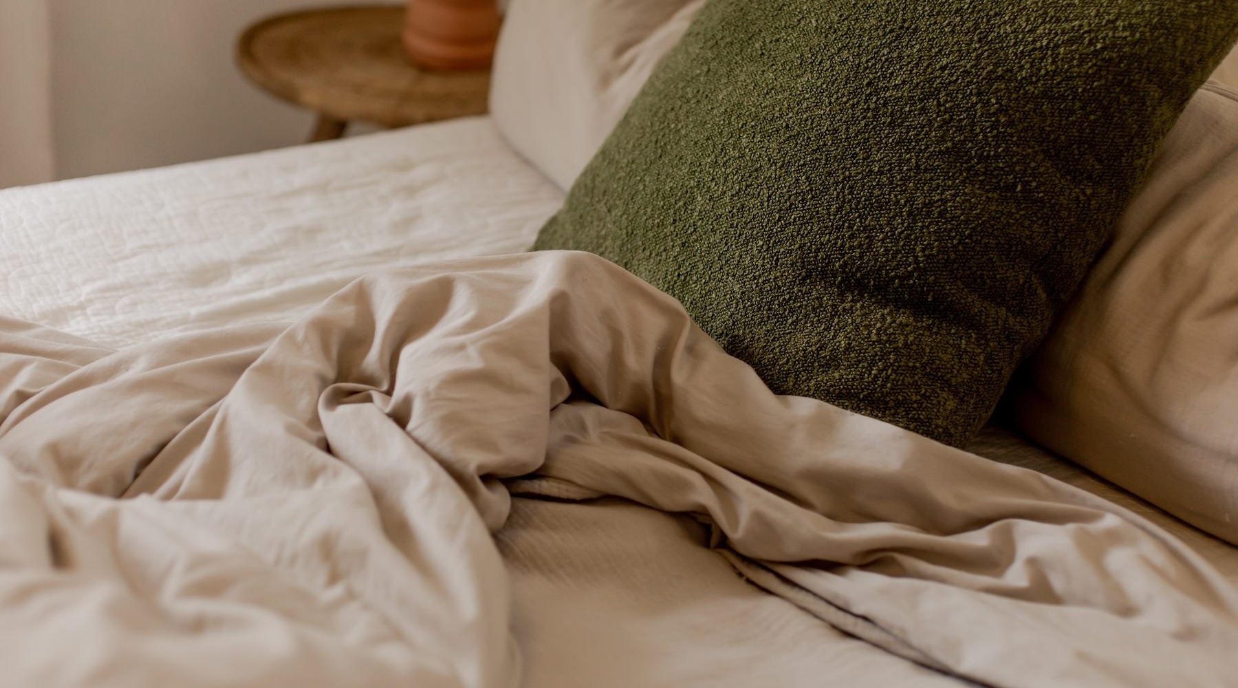 a bed with a green pillow